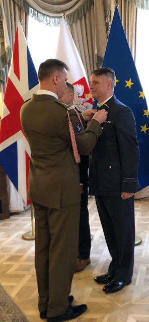 Reverend (Squadron Leader) Mark Perry is presented with the medal by Poland’s Deputy Prime Minister, Władysław Kosiniak-Kamysz.